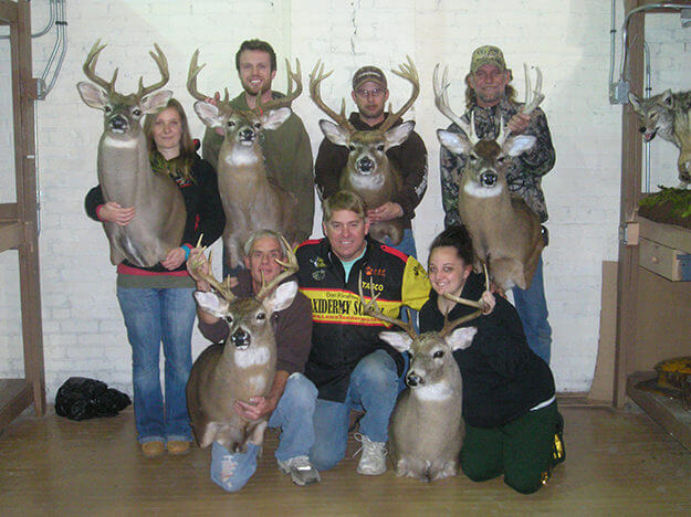 Image of group with taxidermized whitetail mounts